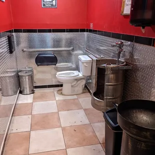 a bathroom with a toilet and a trash can