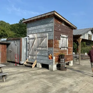 a man standing in front of a small cabin