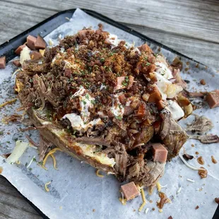 Baked potato with bologna, sliced brisket, and pulled pork.