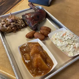 Two meat tray with chop BBQ and 1/4 Chicken. Sides are BBQ BBQ Boiled Potatoes and Coleslaw.