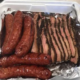a tray of meat and sausages