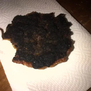 Overcooked, charcoal black Bone Daddy's burger patty.