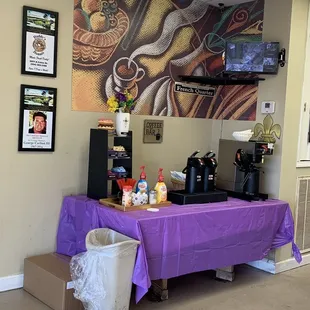 a coffee bar with a purple table cloth