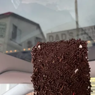 a hand holding a chocolate covered donut