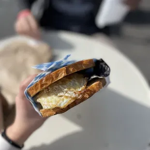 a person holding a sandwich