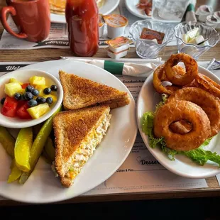 Tuna melt with fresh fruit, extra pickle, and an order of onion rings.