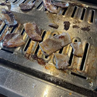 the meat being cooked on the grill