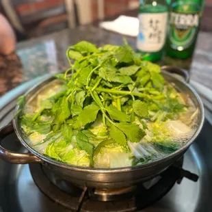 a pot of broccoli and a bottle of beer