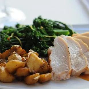 a plate of food with meat, potatoes and broccoli