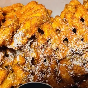 a basket of fried food with a side of dipping sauce