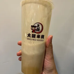 a hand holding a plastic cup with a straw