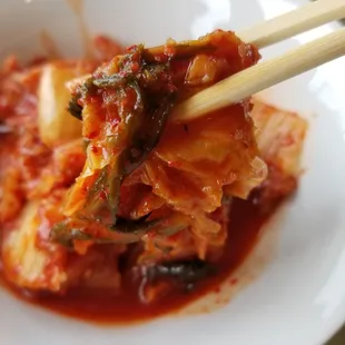 a close up of a plate of food with chopsticks