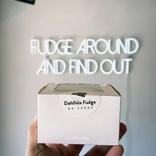 a hand holding a box of fudge around and find out