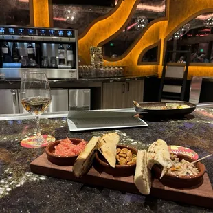 Bar area with a glass of wine and the tapas trio