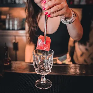 a woman making a cocktail