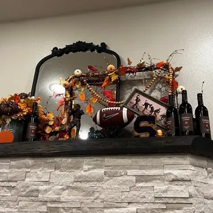 a mantel with bottles of wine and decorations