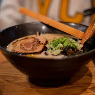 a bowl of ramen with chopsticks