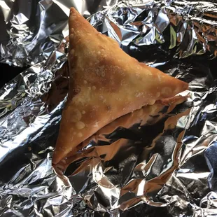 a triangle shaped pastry on aluminum foil