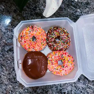 a plastic container filled with chocolate frosting and sprinkles