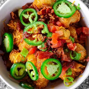 Tater Hater: shredded cheddar, cheese sauce, crumbled bacon, fresh jalapeño, diced tomato &amp; scallion