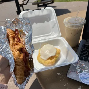 Bacon egg and cheese on a croissant, hazelnut iced latte, buttercream pastry