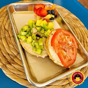 Split Bagel - Toasted Bagel with House Whipped French Onion Cream Cheese, one side with avocado spread and the other with tomato.