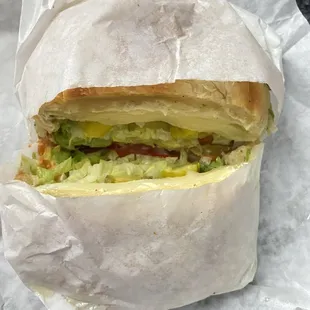 a sandwich wrapped in white paper