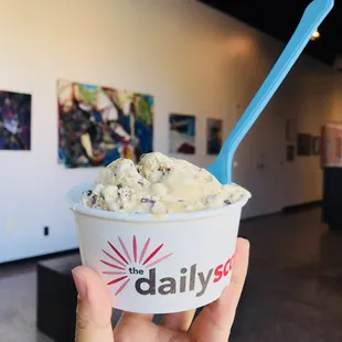 a hand holding a cup of ice cream