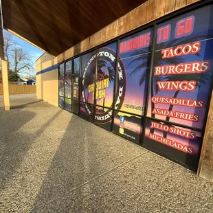 a window with a sign for taco's burgers and wings