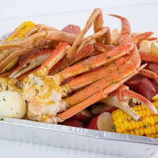 crab legs, potatoes, corn, corn on the cob