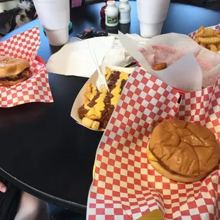 a table full of burgers and fries
