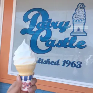 a hand holding an ice cream cone