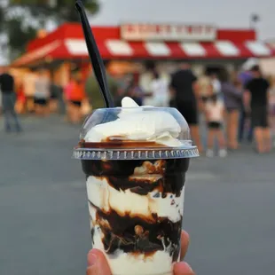 a hand holding a cup of ice cream