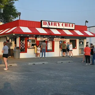 a group of people standing outside of a dairy chef