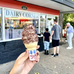 a hand holding a cone of ice cream