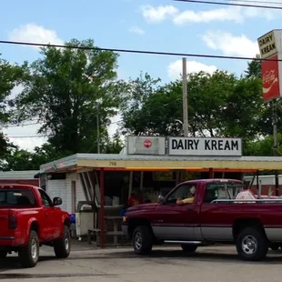 two trucks parked in front of a dairy kream
