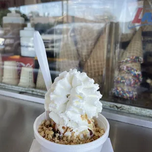 an ice cream sundae with whipped cream and sprinkles