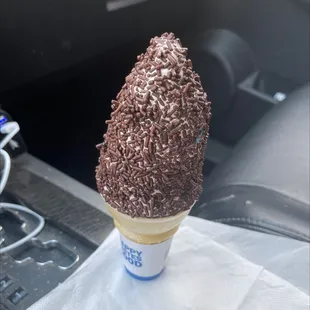 an ice cream cone with chocolate sprinkles