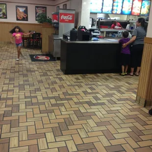 a little girl in a pink dress in a restaurant