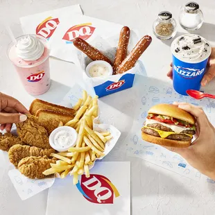 hands grabbing a chicken sandwich and fries