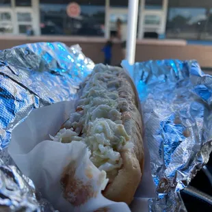 a hot dog wrapped in aluminum foil