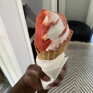 a hand holding an ice cream cone