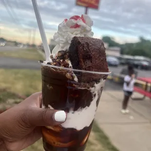 a hand holding a cup of ice cream