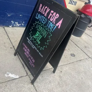 a black for a limited time sign on a sidewalk
