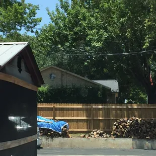 Legit Outside smoker and oak wood pile