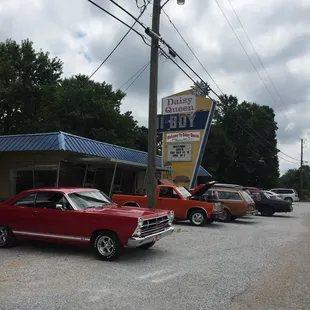 a row of cars parked in front of a motel