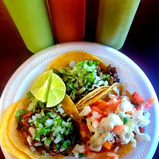 a plate of tacos and a drink