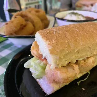 Fried shrimp po boy - delicious!, onion rings (back left), red beans &amp; rice (back right).