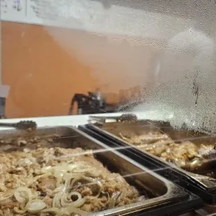 two trays of food being prepared