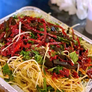 a plastic container filled with pasta and vegetables
